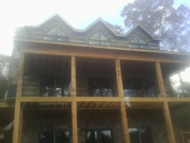 Dormers and porch framing on a large log home under construction — Roof Coating work by our crew in Southington